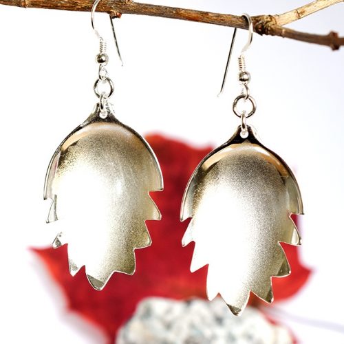 Huurre-lehdet-korvakorut, jotka on muotoiltu hopeisista lusikanpesistä. Korvakorujen reunoissa on sahalaitakuvio.