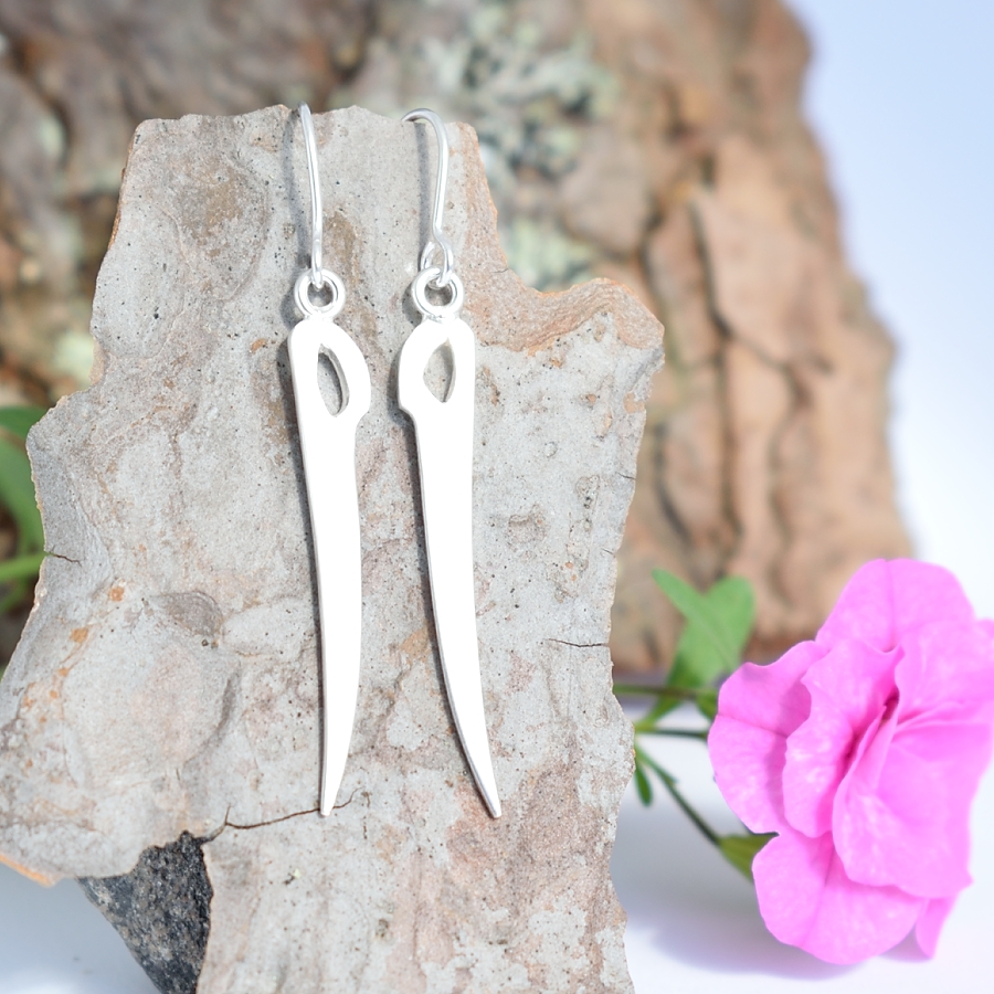 Sapeli-korvakorut, jotka on muotoiltu hopeisesta leikkelehaarukasta sapelin muotoiseksi.