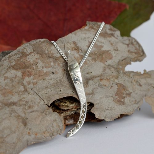 Käärme-riipus, joka on muotoiltu hopeisen keilapalkintolusikan varresta.