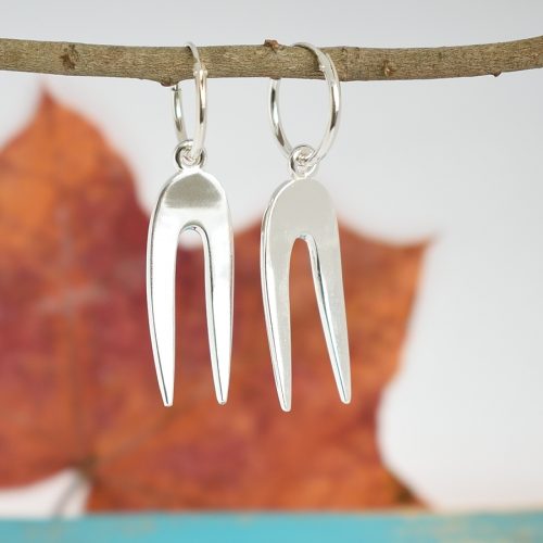 Asenne-korvakorut, jotka on valmistettu pienistä, hopeisista leikkelehaarukoista.