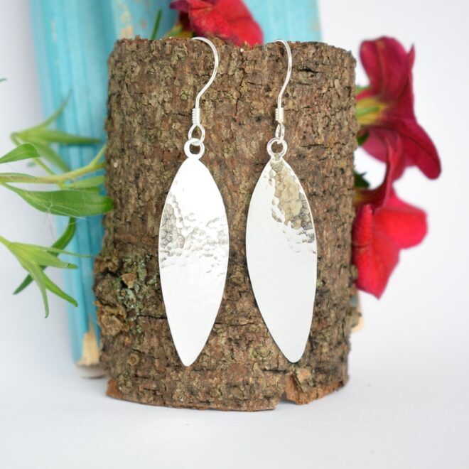 Säde-korvakorut, jotka on muotoiltu hopeaisen lusikan pesästä. Korujen pinta on taottu.