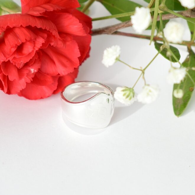 Chippendale-monogrammisormus, joka on muotoiltu hopeisen Chippendale-lusikan varresta. Sormuksen etuosassa on tyylitelty monogrammi, jossa on kirjaimet KP.