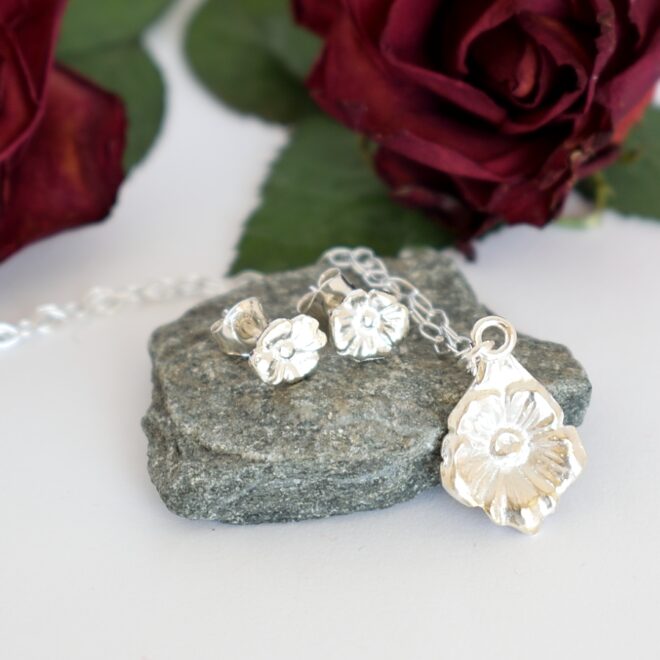 Kukka-korusetti, joka on muotoiltu hopeisten mokkalusikoiden varsista. Pienten tappikorvakorujen koko on 7 x 5 mm ja riipuksen koko on 17 x 12 mm.