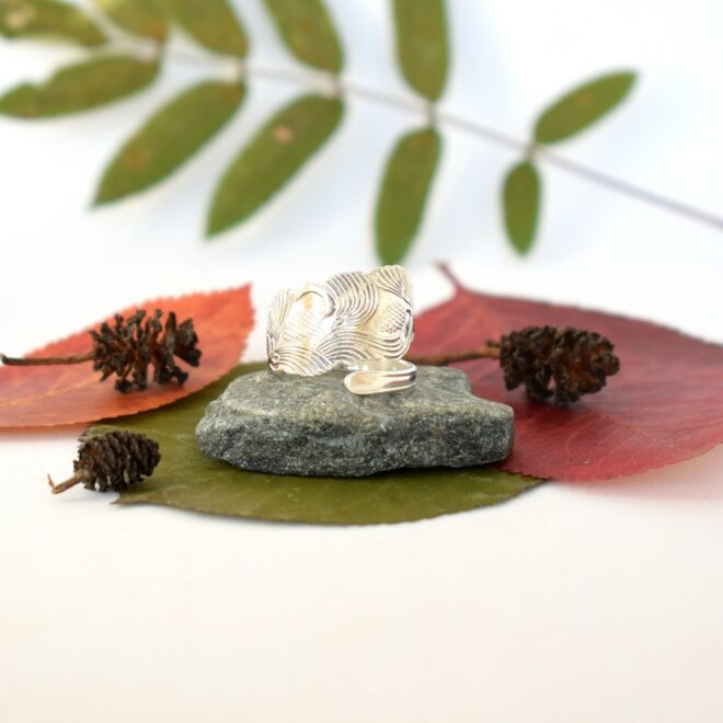 Käpy-kierresormus, joka on muotoiltu kauniin pienen hopeisen käpy-lusikan varresta. Siro lusikka on alun perin valmistettu vuonna 1972