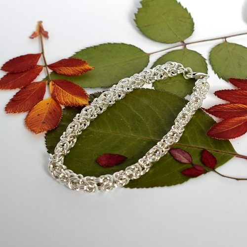 Kuningasketju-rannekoru, joka on punottu käsin 1 mm paksuisesta Sterling-hopealangasta. Näyttävä punottu ketju sopii hyvin miehen ranteeseen.