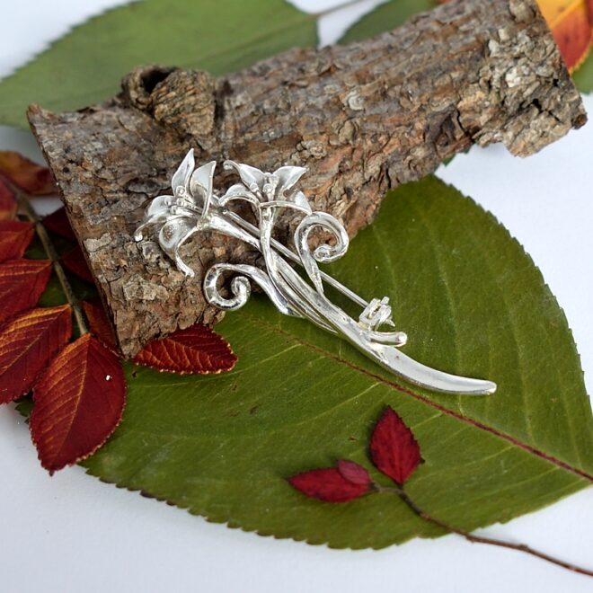 Liljat-rintaneula, joka on kunnostettu ja puhdistettu second hand -tuote. Kaunis rintaneula on Sterling-hopeaa ja todennäköisesti ulkomainen valmiste.