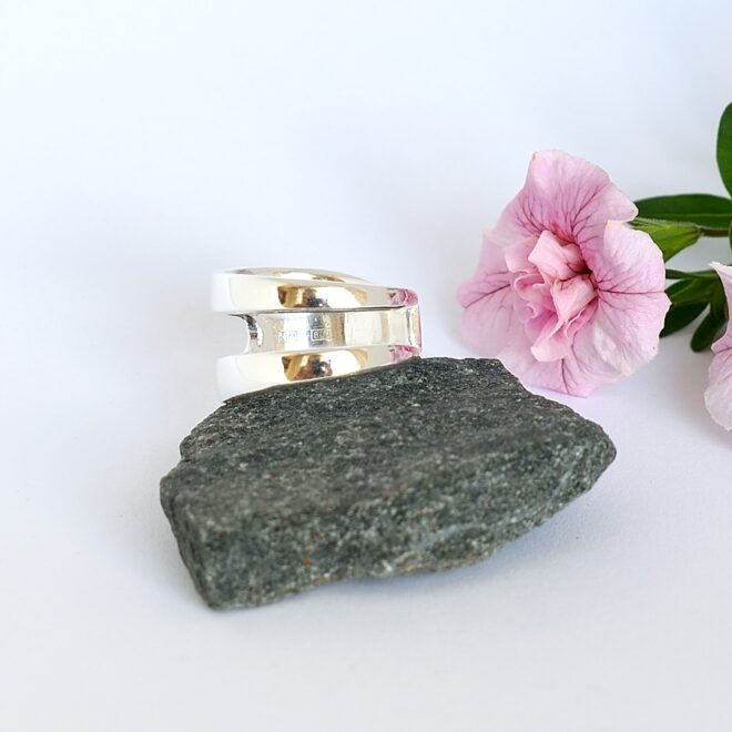 Nea-haarukkasormus, joka on muotoiltu pienestä hopeisesta leikkelehaarukasta. Haarukan piikit on juotettu siten, että piikkien väliin jää rako.