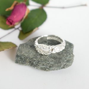 Rokokoo-sormus, joka on muotoiltu Väinö Hamaran suunnittelemasta hopealusikan varren kapeasta osasta.