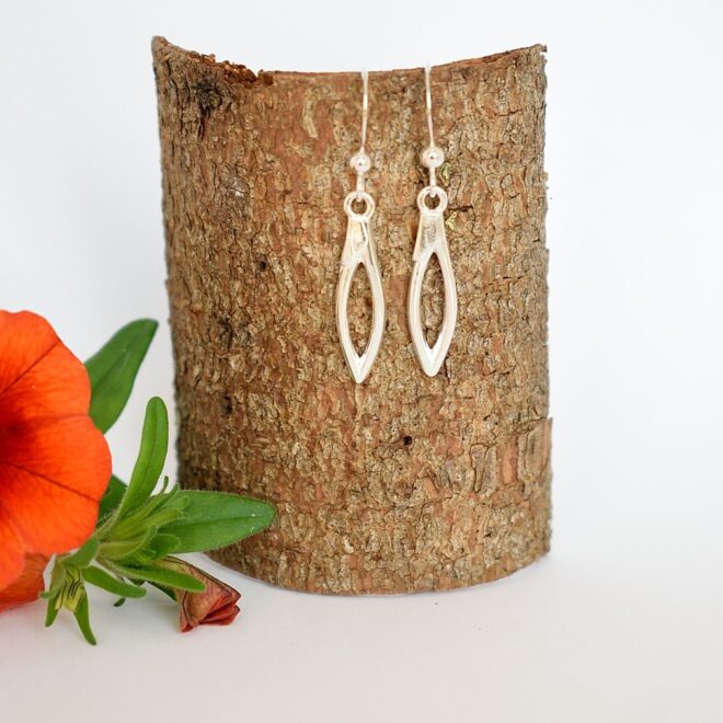 Kuvassa hopeisten lusikoiden varsien silmuista muotoillut sirot korvakorut