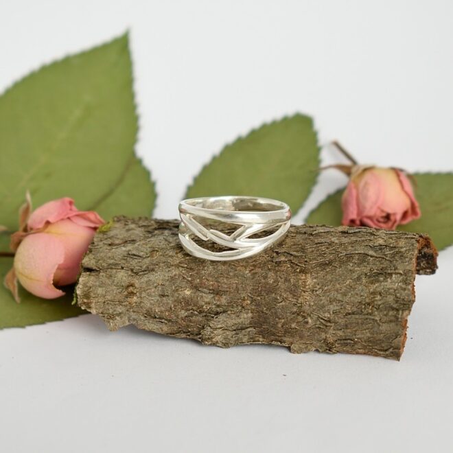 Kuvassa hopeisten lusikoiden varsista käsityönä valmistettu punotun näköinen sormus.