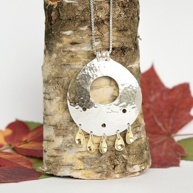 Kuvassa Sunna-riipus, joka on taottu lappilaistyylinen koru laukkasineen.