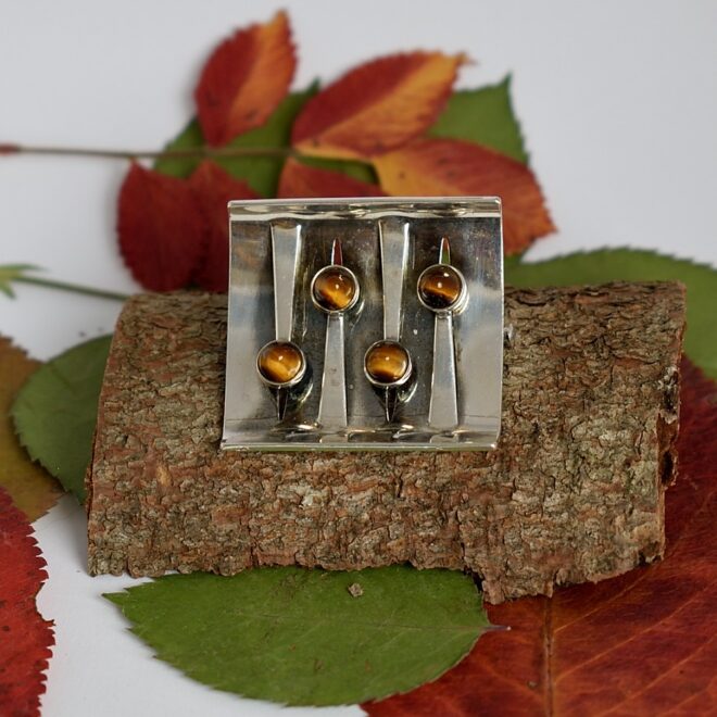 Tiikerinsilmä-rintaneula vaakasuunnassa.