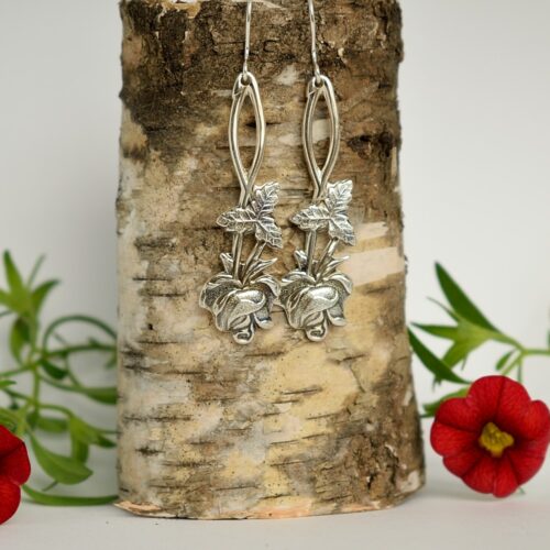 Kuvassa hopeisista Auranruusu lusikoista valmistetut riippuvat pitkät korvakorut.